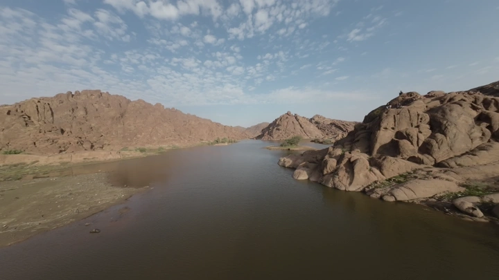 وادي بين الجبال الصخرية تحت سماء صافية، لقطة جوية.