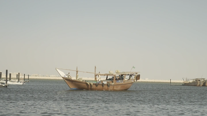 قارب خشبي في البحر خلال النهار، لقطة بعيدة.