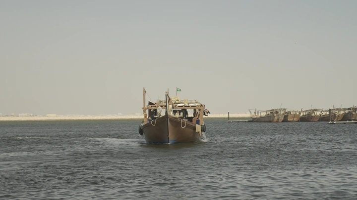 سفينة خشبية في البحر تحت سماء صافية، لقطة أمامية.