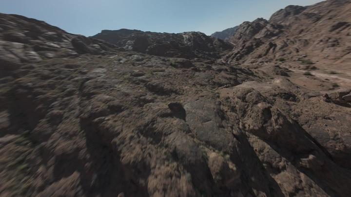 هايكنج في جبال صخرية في حائل تحت ضوء الشمس، لقطة جوية.