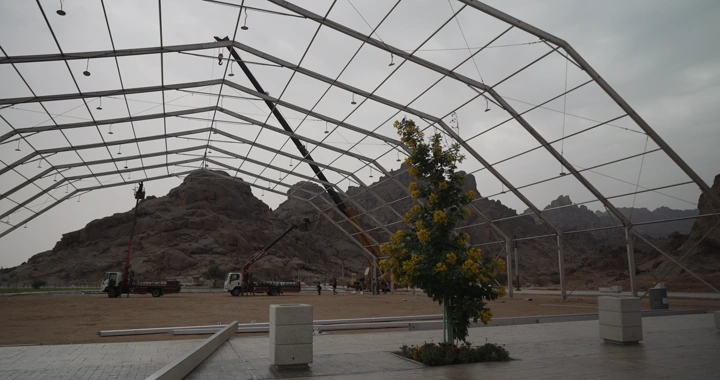 موقع إنشائي في منطقة جبلية، لقطة نهارية.