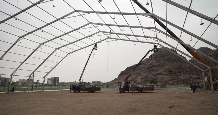 موقع بناء مع رافعات وهياكل معدنية، في وضح النهار، لقطة واسعة.