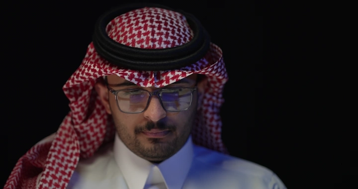 رجل سعودي يرتدي نظارات يعمل، لقطة امامية.