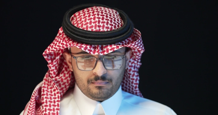 رجل يرتدي نظارات وغترة بيضاء وحمراء، لقطة مقربة.