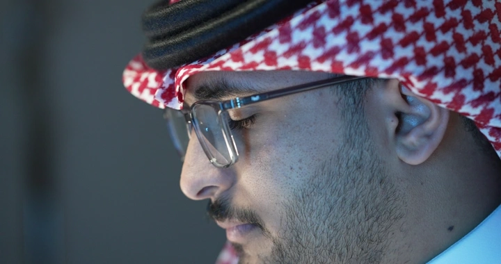 رجل سعودي يرتدي نظارات يعمل، لقطة جانبية.