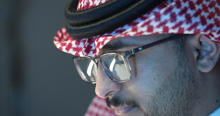 رجل سعودي يرتدي نظارات يعمل، لقطة جانبية.