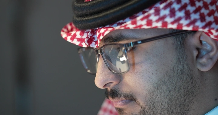 رجل سعودي يرتدي نظارات يعمل، لقطة جانبية.