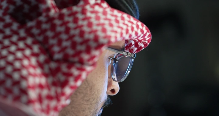 رجل يرتدي نظارات يعمل على جهاز كمبيوتر، لقطة مقربة.