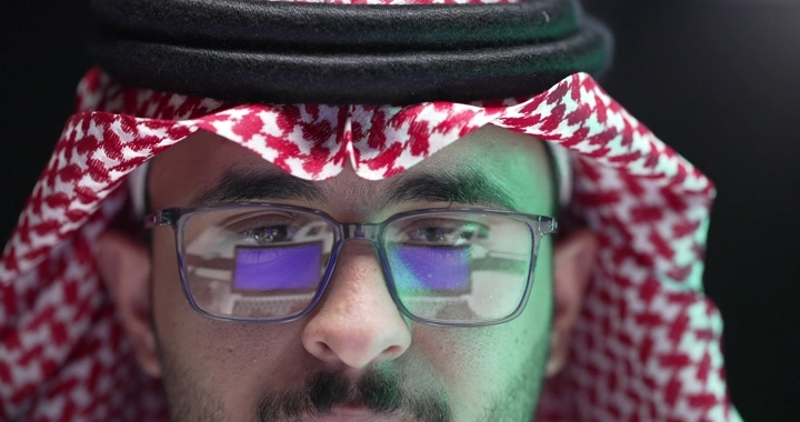 رجل سعودي يرتدي نظارات يعمل على الكمبيوتر، لقطة مقربة.