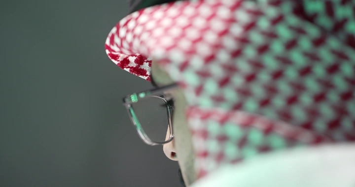 رجل سعودي يرتدي نظارات يعمل، لقطة جانبية.