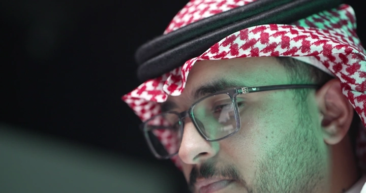 رجل سعودي يرتدي نظارات يعمل، لقطة مقربة.