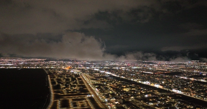 مدينة حائل ليلاً تحت سماء غائمة، صورة جوية.