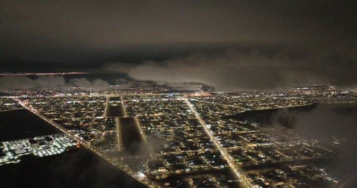 Hail city at night under clouds, aerial shot.
