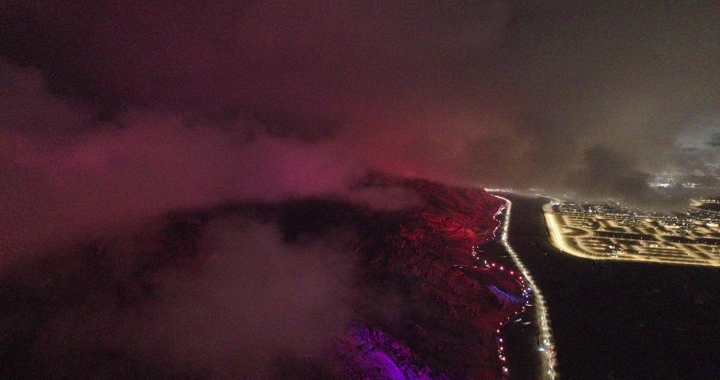 منظر جوي لحائل ليلاً تحت الغيوم، إضاءة حمراء وبنفسجية.