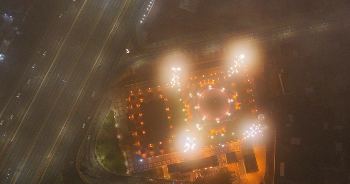 صورة جوية  لمسجد الراجحي لمدينة حائل ليلاً مع أضواء مضيئة والجو غائم.