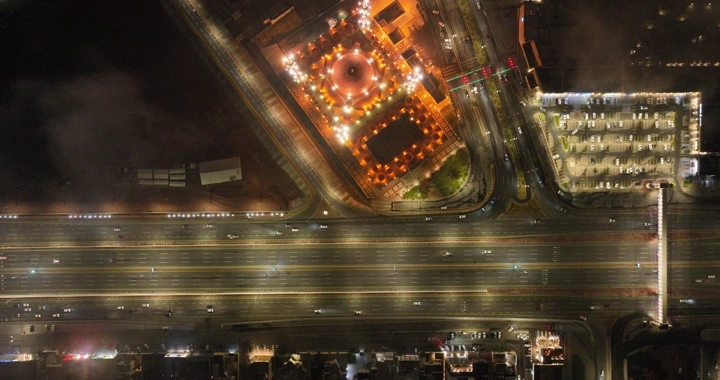 صورة جوية لمدينة حائل ليلًا مع أضواء الشوارع والجو غائم.