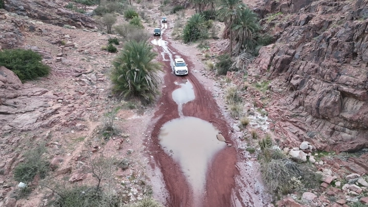 سيارة تسير في طريق جبلي بعد الأمطار، لقطة جوية.