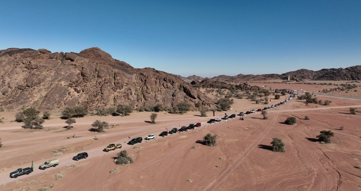 تجمع سيارات دفع رباعي في الصحراء بجانب الجبال، لقطة جوية.