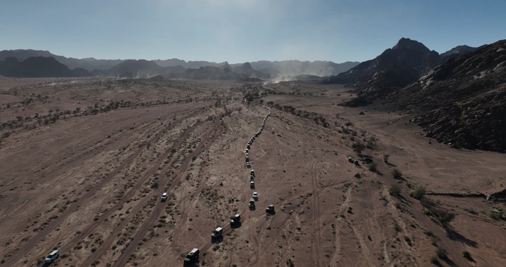 تجمع سيارات دفع رباعي في صحراء جبلية، لقطة جوية.