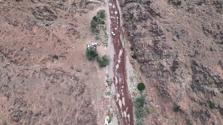 سيارة تسير في طريق جبلي بعد المطر، لقطة جوية.