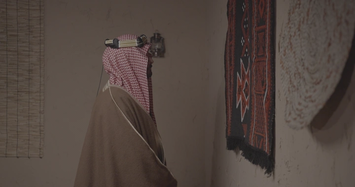 رجل سعودي يلمس سدو في غرفة تقليدية، لقطة جانبية.