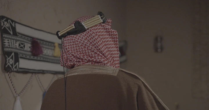 رجل سعودي يلمس سدو في غرفة تقليدية، لقطة جانبية.