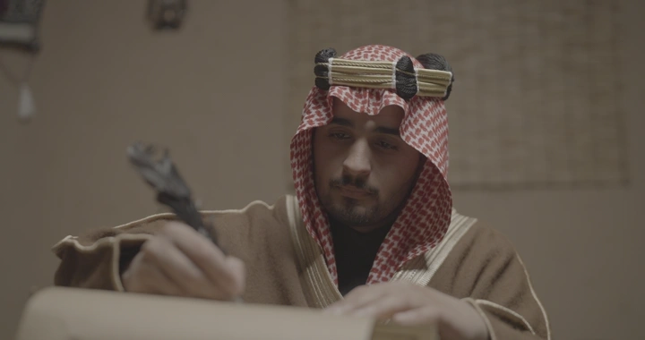 رجل سعودي يكتب في يوم التأسيس، لقطة داخلية.