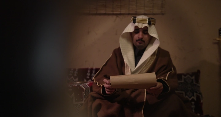 رجل سعودي يقرأ وثيقة في يوم التأسيس، لقطة داخلية.