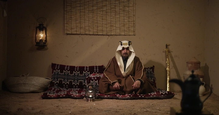 رجل سعودي يجلس في غرفة تقليدية مع سيف، تصوير داخلي.