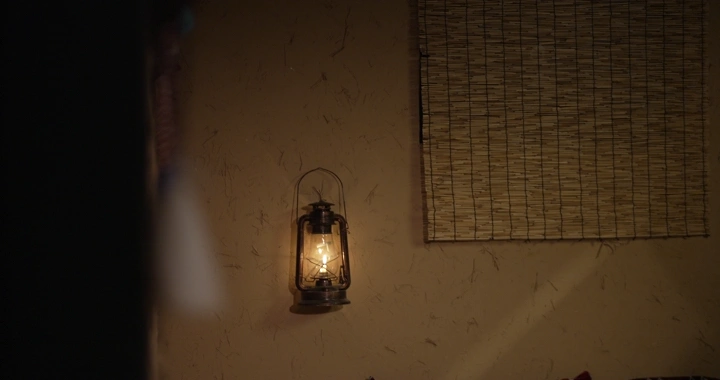 مصباح قديم معلق على جدار في غرفة تقليدية، لقطة داخلية.