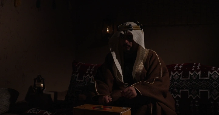 رجل سعودي في غرفة تقليدية مظلمة، تصوير داخلي.