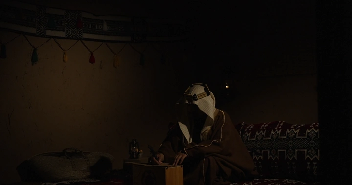 رجل سعودي يكتب في يوم التاسيس ، إضاءة خافتة.