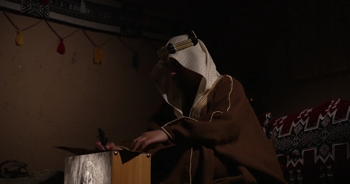 رجل سعودي يكتب في يوم التأسيس، إضاءة خافتة.