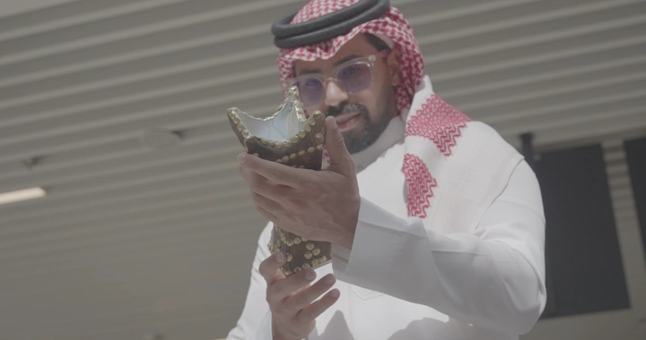 رجل يحمل مدخنة مصنوعة يدوية في مكان داخلي، لقطة قريبة.