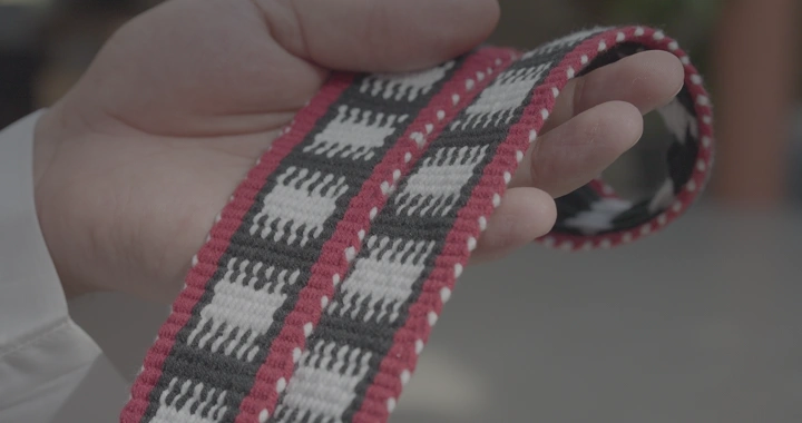 شخص يحمل قطعة سدو منسوجة يدوياً، لقطة قريبة.