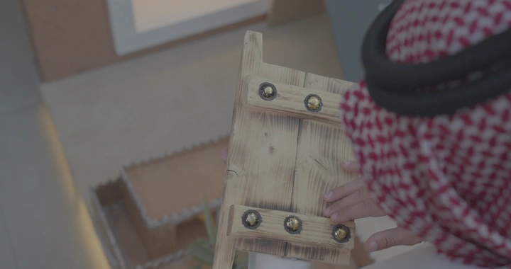 شخص يحمل بوابة مصغرة مصنوعة يدوياً، تصوير قريب.