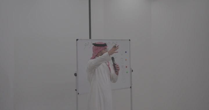 رجل يشرح للطلاب في فصل دراسي، لقطة داخلية.