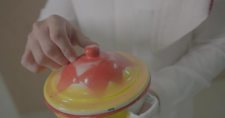 يد تفتح حافظة طعام ملونة، لقطة مقربة.