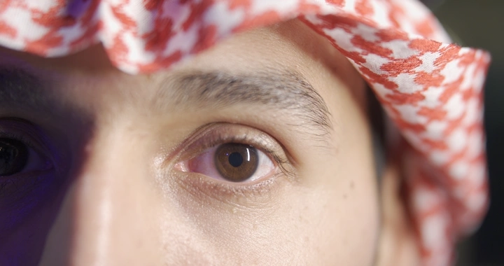 عين رجل يرتدي شماغ أحمر وأبيض، لقطة قريبة.