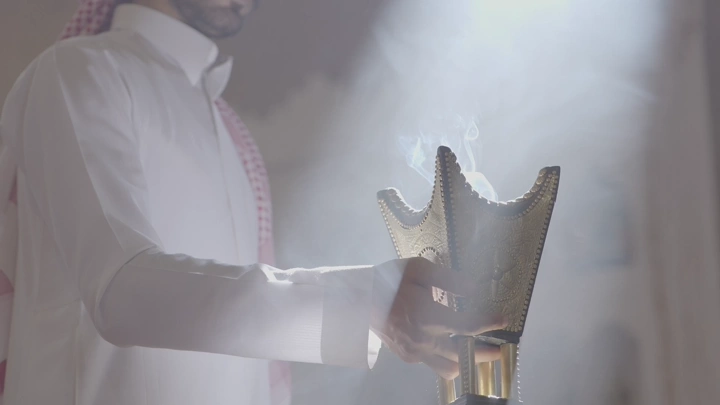 رجل يحمل مبخرة في غرفة مضاءة، لقطة جانبية.