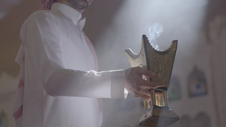 رجل يحمل مبخرة في غرفة مضاءة، لقطة مقربة.