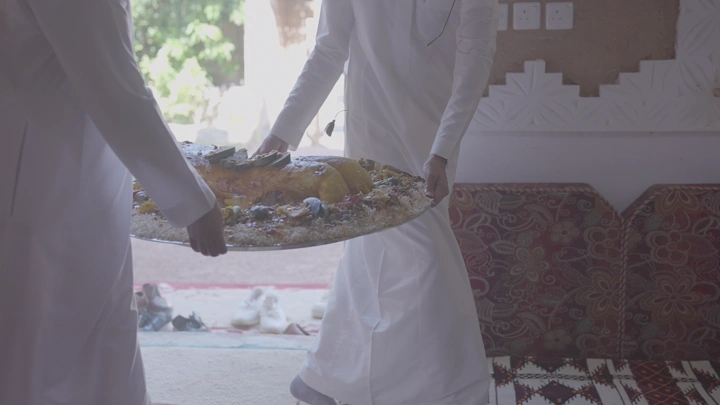 تقديم طبق مفطح لحم في مجلس عربي، لقطة داخلية.