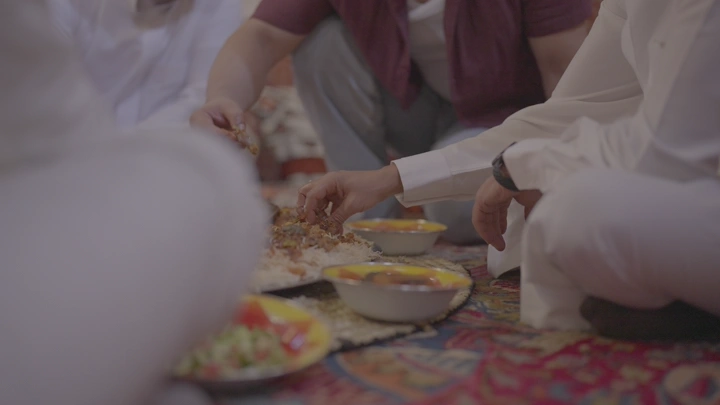 رجال يتناولون مفطح لحم في عزيمة، لقطة قريبة.