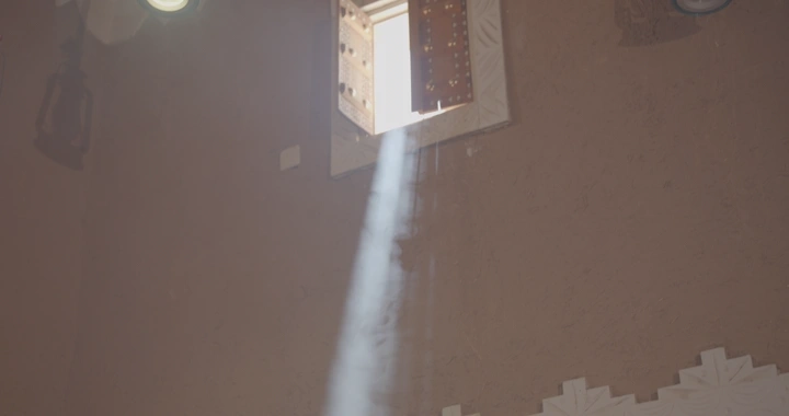 أشعة الشمس تخترق نافذة في مجلس تراثي، لقطة داخلية.