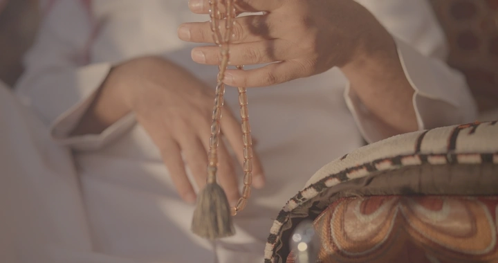 يد تحمل سبحة في ضوء الشمس، لقطة قريبة.