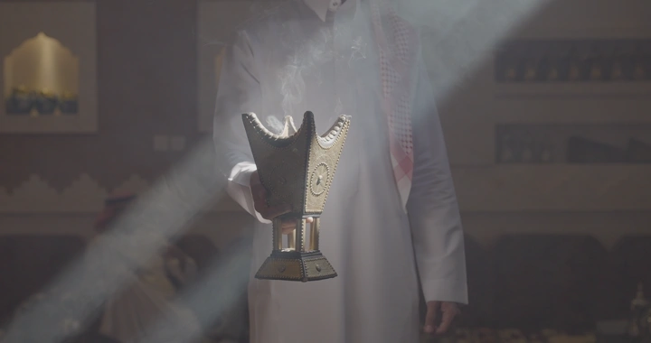 رجل يحمل مبخرة في غرفة تقليدية، إضاءة ناعمة.