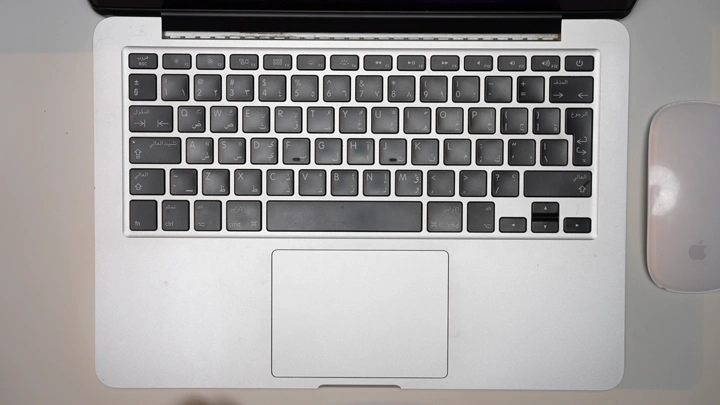 رجل يدخل البيانات على لوحة مفاتيح في مكتب، لقطة من الأعلى.