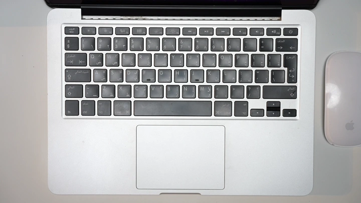 رجل يدخل البيانات من خلال لوحة مفاتيح في مكتب داخلي، لقطة من الأعلى.