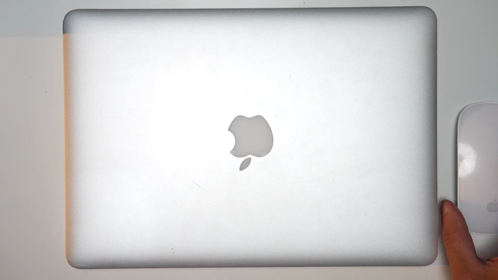 شاب يستعد للعمل على لابتوب في مكتب، لقطة من الأعلى.