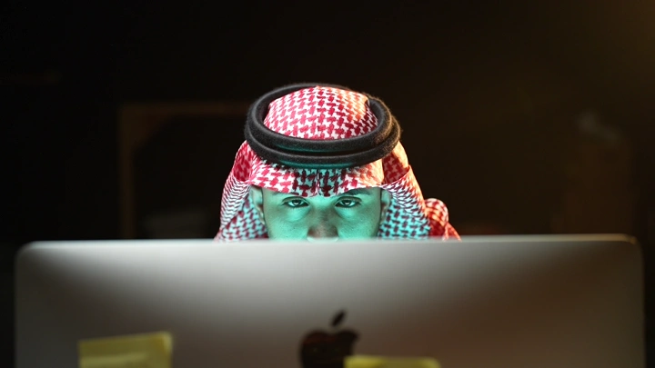 لقطة على العيون رجل سعودي يعمل على جهاز كمبيوتر في مكتب، لقطة أمامية.